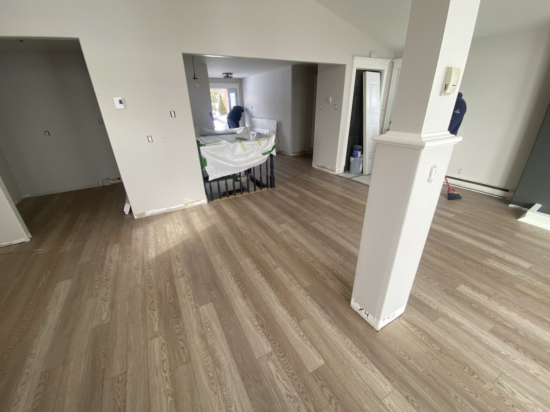 Open-concept living area with new wood-look plank flooring installed