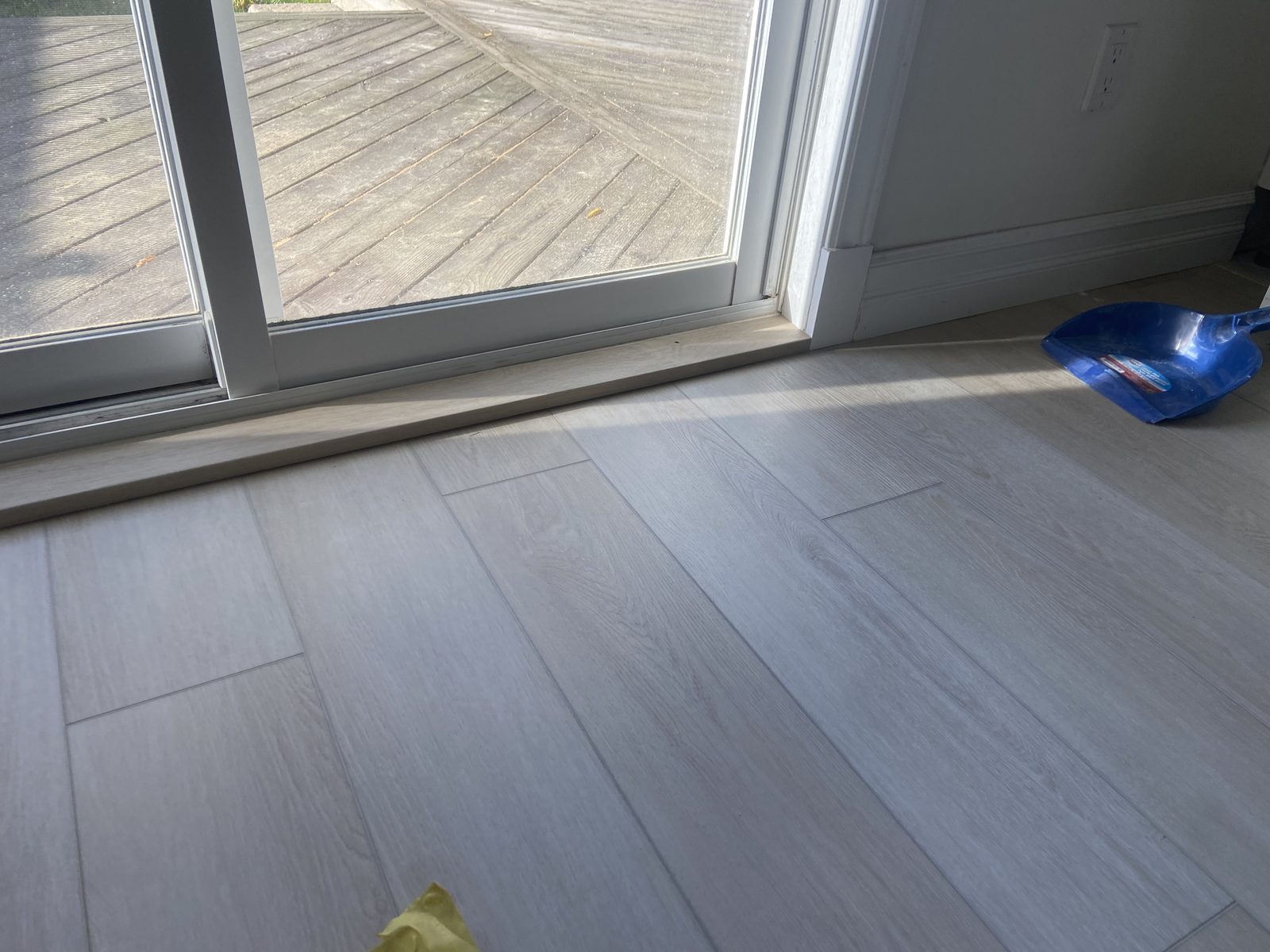 New light plank flooring running up to a patio slider door
